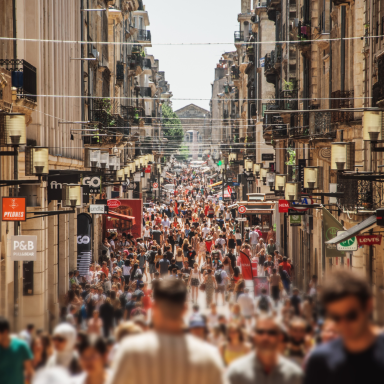 Crowded Parisian street lined with shops, symbolizing brand identity development and visual communication in a dynamic marketplace.