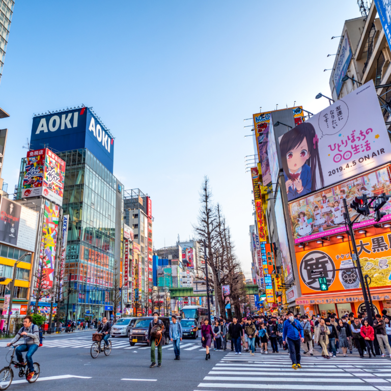 Tokyo cityscape filled with colorful ads and busy pedestrians, illustrating high-impact visual design and branding materials