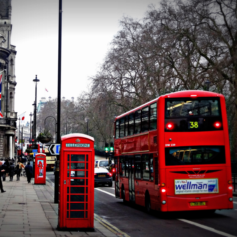 Classic red London bus and telephone booth on a gray city street, symbolizing strategic consultancy and brand positioning